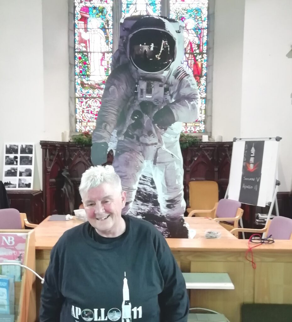 A cardboard Buzz Aldrin looking great infront of a massive stained glass window in Ballinrobe Library