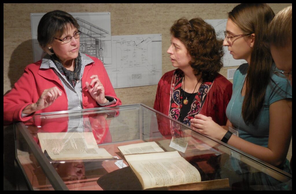 Prof. Buie discussing Copernicus with KAS attendees.  Inside the case, to the left, is an original copy of Copernicus’s De Revolutionibus.  In the foreground is an original copy of Isaac Newton’s Principia, with notes written in it by Newton himself.  See below.