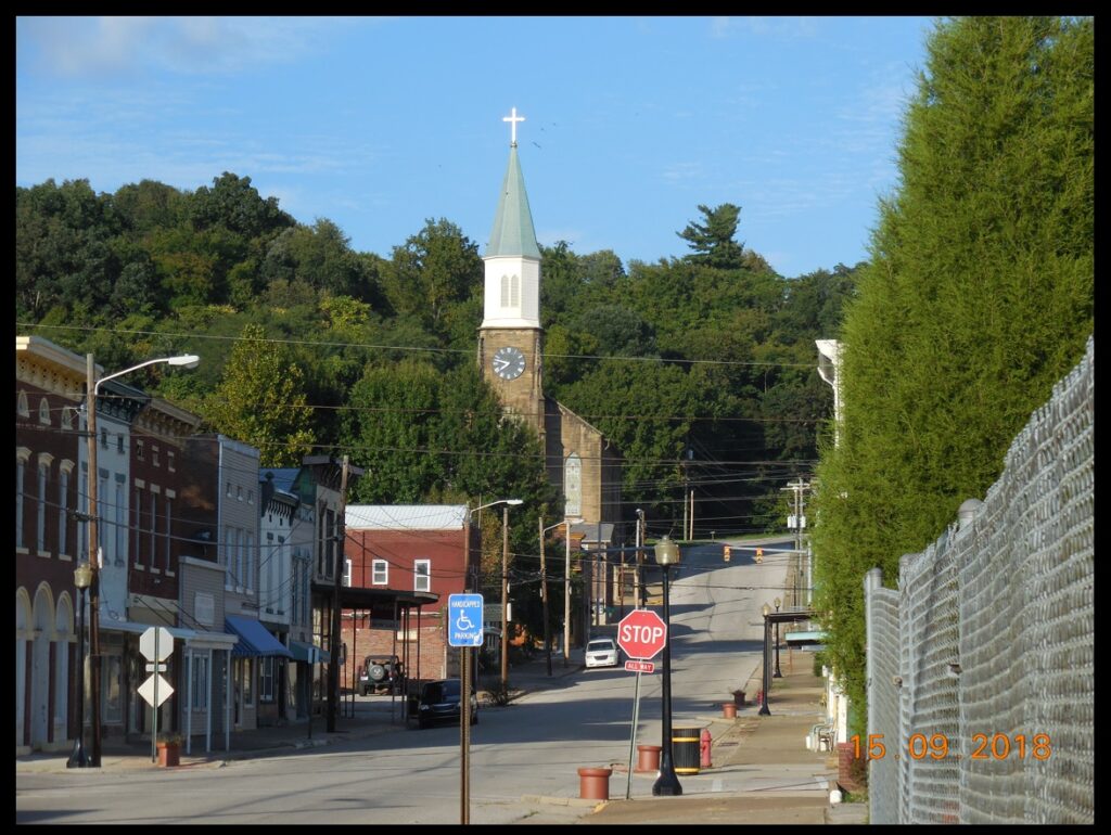 St. Michael’s Church and Washington Street in Cannelton. According to the book St. Michael’s On the Hill & St. Patrick’s Church, St. Michael’s was constructed in 1858-1859 from stone quarried from a nearby cliff (which had also been the source for the stone in the Cotton Mill) and mortared with an unusual mixture that included buttermilk and required involvement of many households to supply the ingredients.