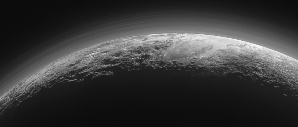 Pluto’s Majestic Mountains, Frozen Plains and Foggy Hazes: Just 15 minutes after its closest approach to Pluto on July 14, 2015, NASA’s New Horizons spacecraft looked back toward the sun and captured this near-sunset view of the rugged, icy mountains and flat ice plains extending to Pluto’s horizon. The smooth expanse of the informally named icy plain Sputnik Planum (right) is flanked to the west (left) by rugged mountains up to 11,000 feet (3,500 meters) high, including the informally named Norgay Montes in the foreground and Hillary Montes on the skyline. To the right, east of Sputnik, rougher terrain is cut by apparent glaciers. The backlighting highlights over a dozen layers of haze in Pluto’s tenuous but distended atmosphere. The image was taken from a distance of 11,000 miles (18,000 kilometers) to Pluto; the scene is 780 miles (1,250 kilometers) wide. Credits: NASA/JHUAPL/SwRI