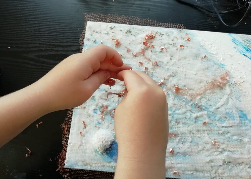 Cal helps sprinkle the copper shavings all over the canvas. They represent the dunes on Mars as imaged by NASA Odyssey spacecraft