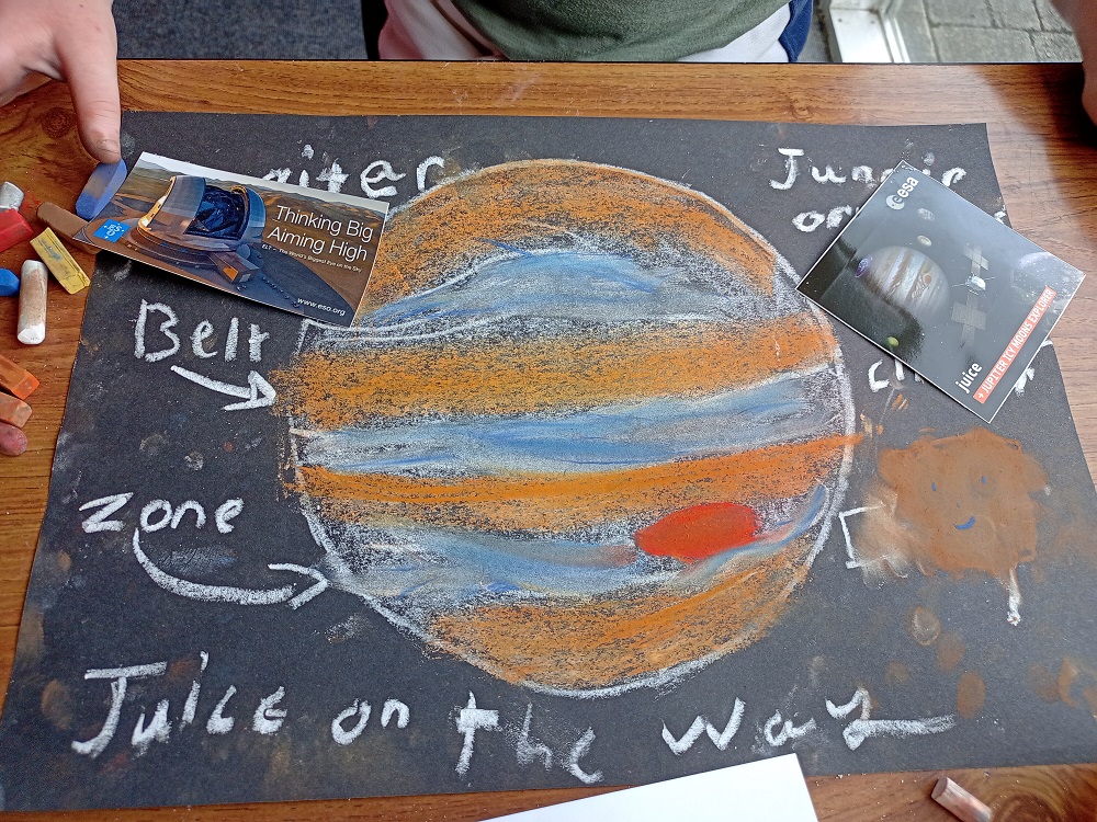 A drawing of Jupiter with its belts and zones . Showing spacecraft on the way and there already